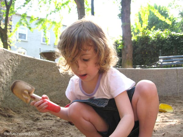 Lila at 3 years old playing in the sand box.