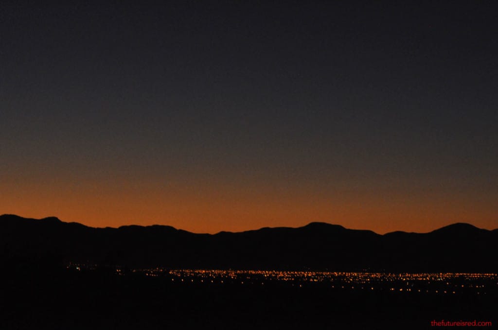 Early morning sunrise in Salta. Orange red sky match the city lights.
